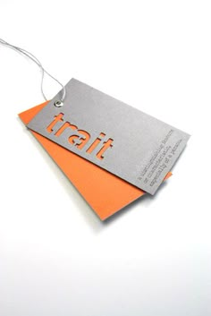 an orange and gray tag with the word trail on it