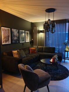 a living room filled with furniture next to a tall glass window covered in curtains and lights