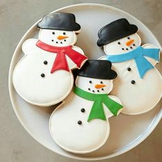 three decorated snowmen on a white plate