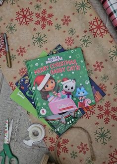 the children's christmas card book is laying next to scissors and other crafting supplies