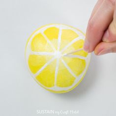 someone is painting a lemon with white paint