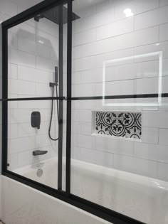 a bath tub sitting under a window next to a shower head and faucet