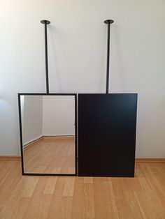 two mirrors sitting on top of a wooden floor next to each other in front of a white wall