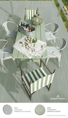 an outdoor table and chairs on a deck with food laid out for two people to eat