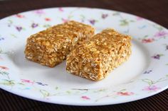 two pieces of granola on a white plate with floral print pattern and flowers around it