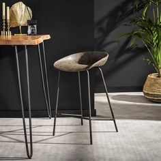 two stools sitting next to each other in front of a table with a plant on it