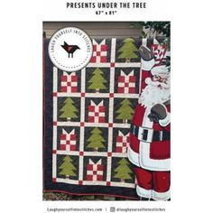 a christmas quilt with santa claus holding a tree on it's chest and standing next to a wall hanging