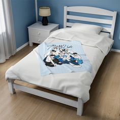 a bed in a bedroom with blue walls and white furniture, along with an anime themed comforter