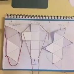 an open notebook with paper cut out and string attached to it