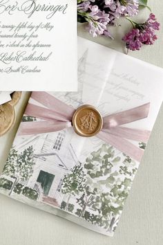 the wedding stationery is laid out on top of some cards and envelopes with a wax stamp