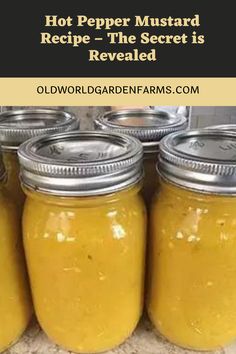 four jars filled with yellow liquid sitting on top of a counter