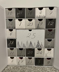 a wall mounted calendar with numbers and trees on it