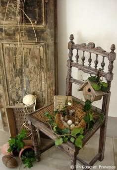 an old chair with birds nest in it next to a potted plant and bird house