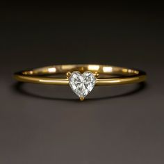 a heart shaped diamond ring on a black background