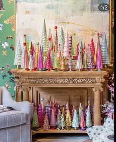 a living room filled with lots of colorful christmas trees on top of a fireplace mantel