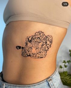 a woman's stomach with a tattoo of a cheetah on the side