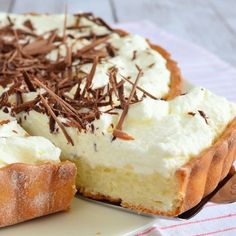 a piece of cake on a plate with chocolate shavings and whipped cream topping