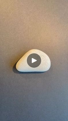 a white rock sitting on top of a gray table next to a black and white clock