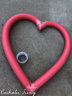 a red heart shaped hose laying on the ground