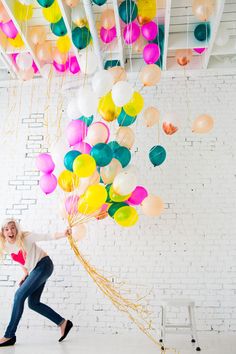 a room filled with lots of balloons floating from the ceiling