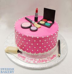 a birthday cake with makeup and cosmetics on it