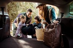 a woman and two children in the back of a car