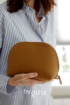 a woman holding a brown purse in her hands