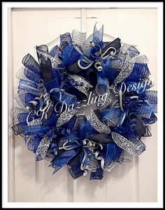 a blue and silver mesh wreath with the word royal written on it, hanging on a white door