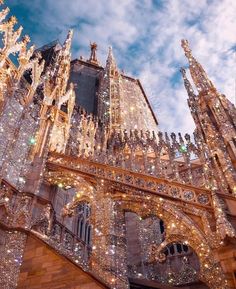 an ornate building with lights on it's side and the sky in the background