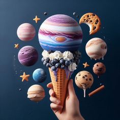 a hand holding an ice cream cone filled with planets