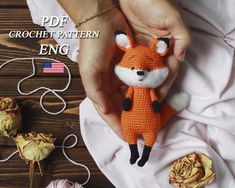 a crocheted fox is being held by someone's hands