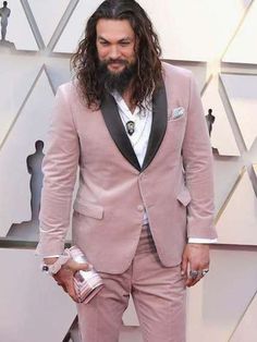 a man with long hair and beard wearing a pink suit on the oscars red carpet