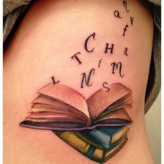 a woman's thigh with an open book tattoo on her left side ribcage