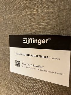 a close up of a sign on a wall near a chair with the name eiffringer