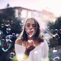 a woman is blowing soap bubbles in the air