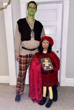 a man and woman in costume standing next to each other on the floor near a door