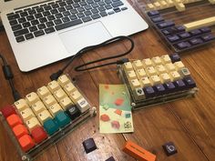 a laptop computer sitting on top of a wooden table next to an assortment of keys