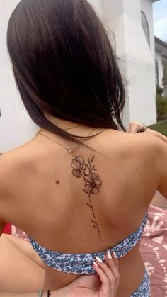 a woman with a flower tattoo on her back