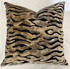 a brown and black zebra print pillow sitting on top of a bed