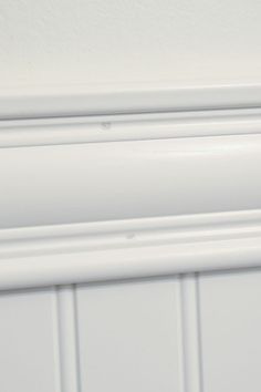 a close up of a white cabinet door handle