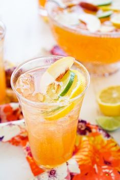 two glasses filled with orange juice and garnished with sliced lemons on a table