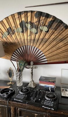 an old fashioned fan is on top of a table in front of a record player