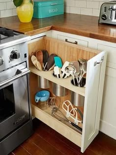 an open cabinet in the kitchen with utensils