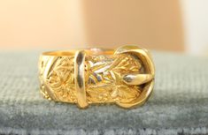 This is a substantial and well made Chased Buckle Ring in 18K yellow gold.  It is 8.6 grams in size 10.5.   It is 12 mm at the buckle and is hallmarked Birmingham, 1917 and 18K gold. Gold Art Nouveau Ring For Formal Occasion, Art Nouveau Gold Engraved Rings, Art Nouveau Style Gold Engraved Rings, Art Nouveau Style Engraved Gold Rings, Vintage Gold Engraved Ring, Buckle Ring, Bird Feathers, Rings Statement, Birmingham