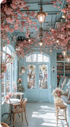 the inside of a store with flowers on the ceiling and tables in front of it