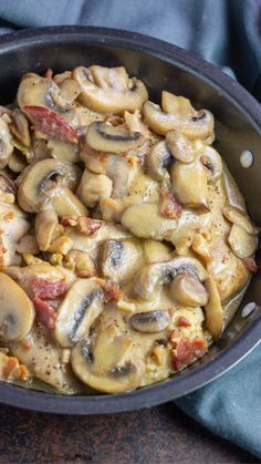 a skillet filled with mushrooms on top of a table