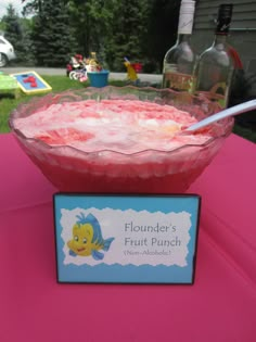 a pink table with a bowl of food on it and a sign that says flounder's fruit punch