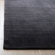 a black rug on the floor with white tiles