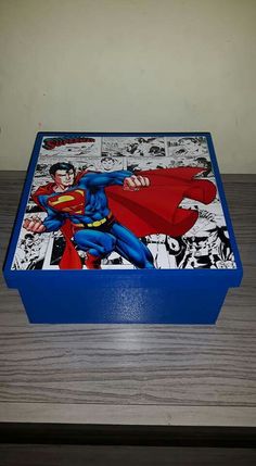 a superman comic box sitting on top of a wooden table