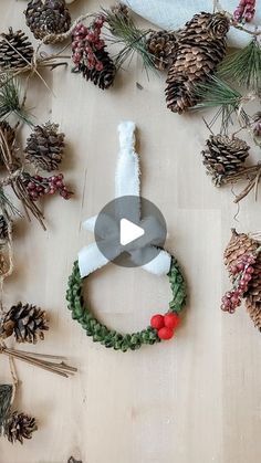 christmas wreath made out of pine cones and other holiday decorations on a wooden surface with text overlay